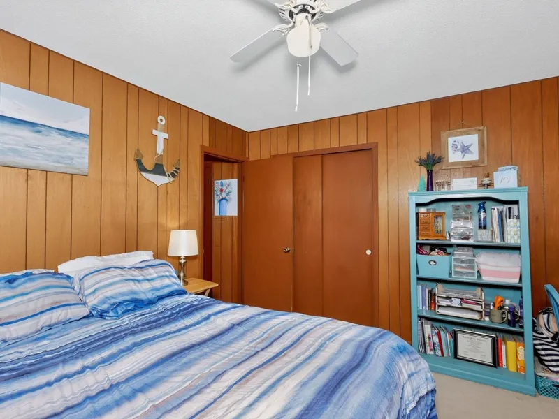 Bedroom with wood paneling and a window