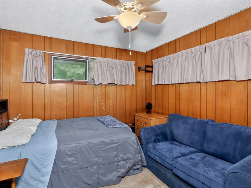 Bedroom with wood paneling and a bed
