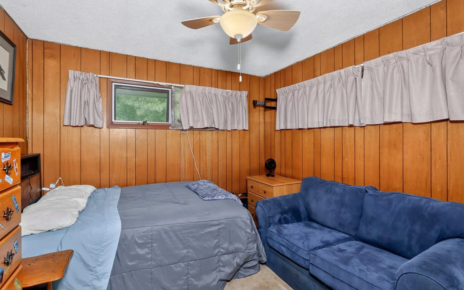Bedroom with wood paneling and a bed