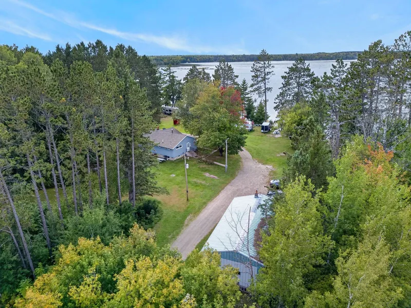Aerial view of the property, shoreline, and Shallow Lake