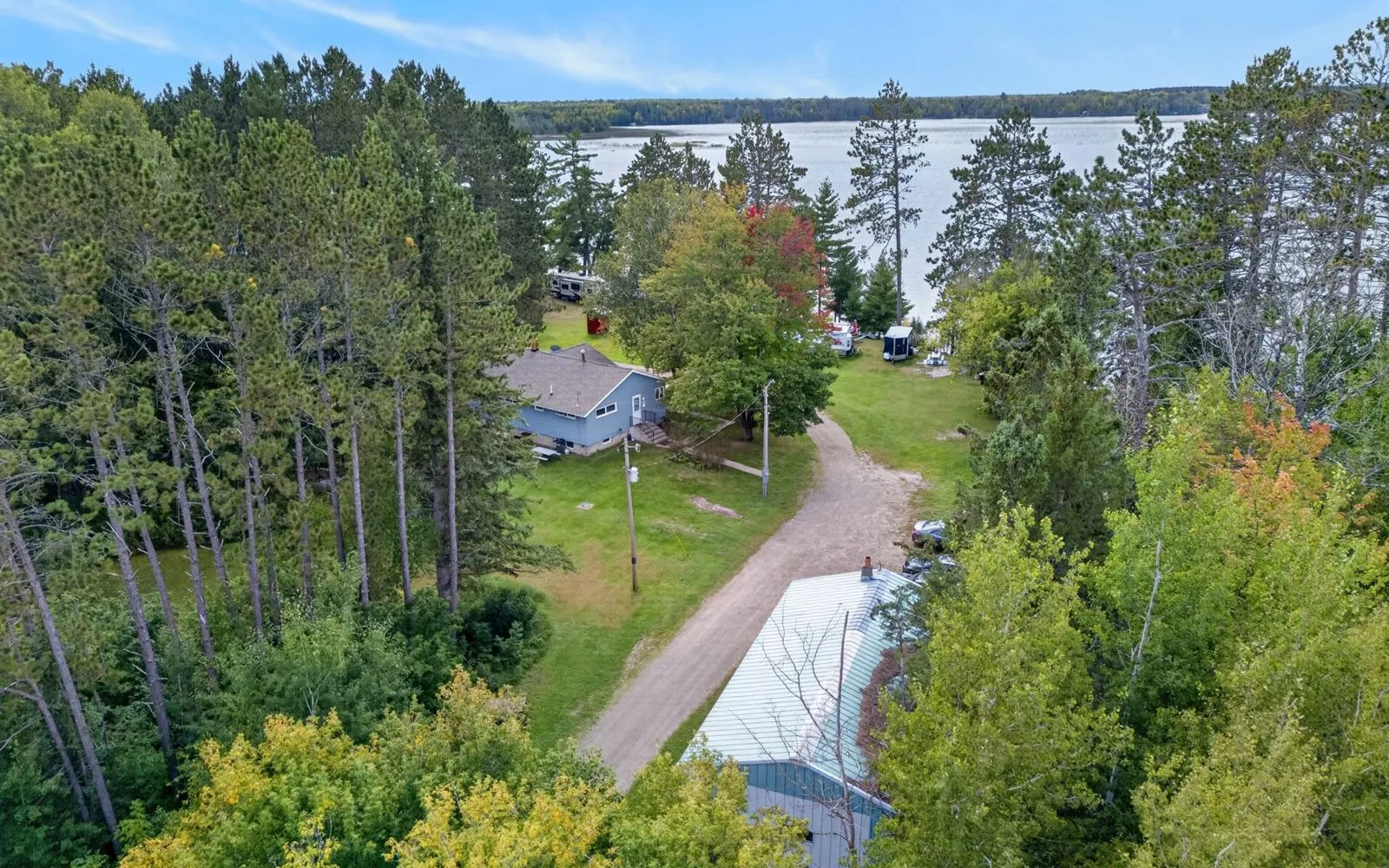 Aerial view of the property, shoreline, and Shallow Lake